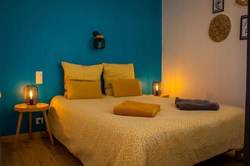 a blue bedroom with a bed with two lights on it at Le Sardinier in Camaret-sur-Mer