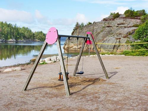 two swings on a beach next to the water at 5 person holiday home in MUNKEDAL in Munkedal