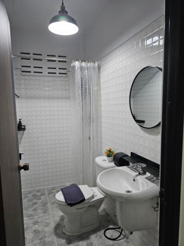 a bathroom with a sink and a toilet and a mirror at 34house in Betong
