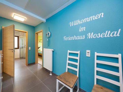 a room with a blue wall with a ladder and a chair at Holiday home Moselle valley in Maring-Noviand