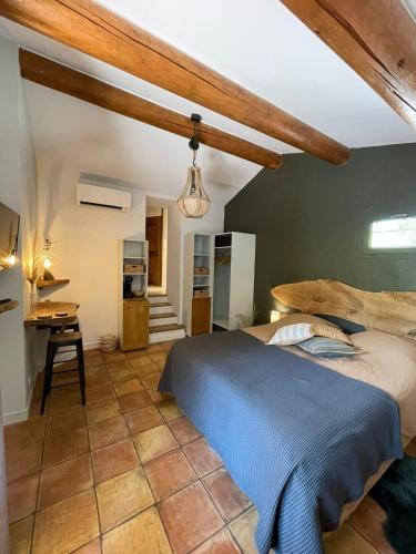 une chambre avec un grand lit et une cuisine dans l'établissement Cyprès du château, à Le Barroux