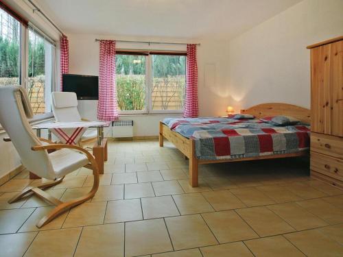 ein Schlafzimmer mit einem Bett, einem Schreibtisch und einem Stuhl in der Unterkunft Ferienhaus am Wockersee in Parchim in Parchim