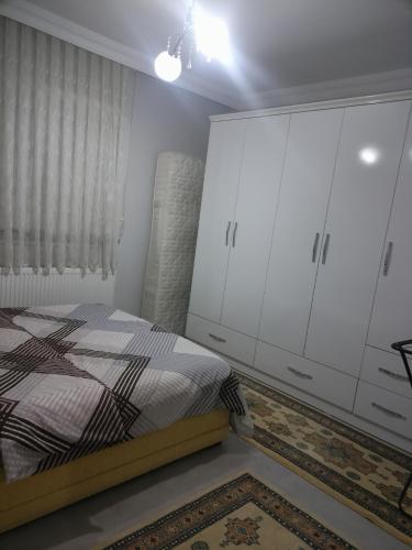 a bedroom with a bed and white cabinets at HAMZAOĞLu KONAK in Atakum