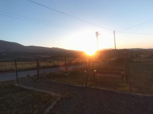 a bench in a field with the sunset in the background at HAMZAOĞLu KONAK in Atakum