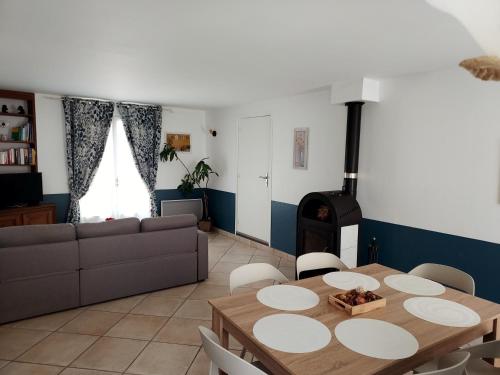 - un salon avec une table et un poêle à bois dans l'établissement Maison en plein coeur du Vexin, à Drocourt