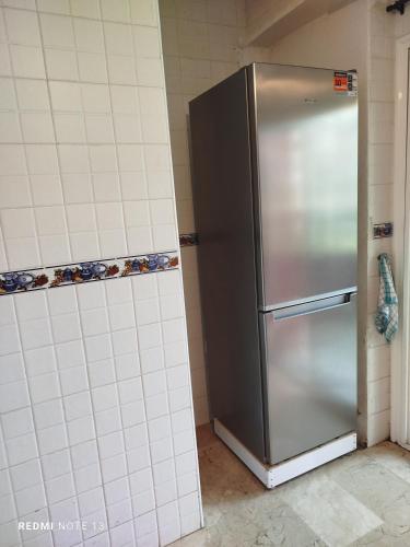 a stainless steel refrigerator in a corner of a kitchen at appartement au bord de l'eau in Mohammedia