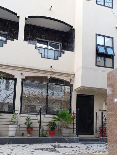 a white building with potted plants in front of it at Belle maison familiale spacieuse à Dakar Sénégal HOME TERANGA in Dakar