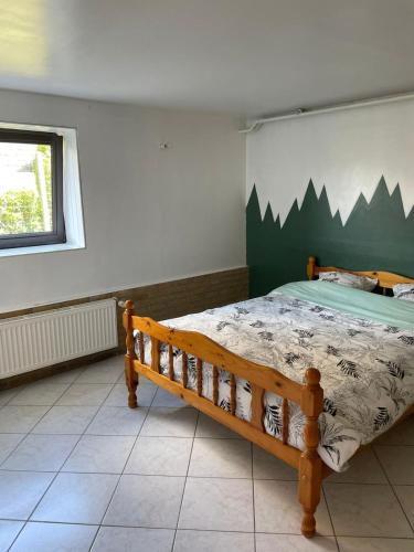 une chambre avec un lit en bois dans une pièce dans l'établissement Le Bibrou Appartement 2 chambres, à Heuringhem