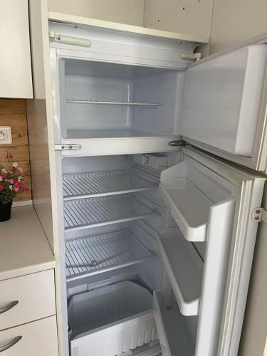 un réfrigérateur vide avec sa porte ouverte dans une cuisine dans l'établissement Le Bibrou Appartement 2 chambres, à Heuringhem