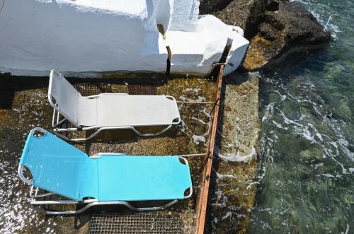 an overturned blue and white boat on the water at Fisherman's Syrma House in Pachaina