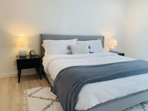 a bedroom with a large bed with two lamps on tables at Brand New Basement Apt with Hot Tub in Colorado Springs