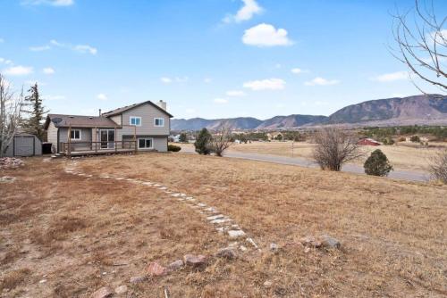 a house on the side of a field with a road at Beautiful Mountain Views Close to Hiking Trails in Monument