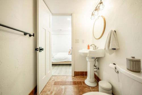 a bathroom with a sink and a toilet and a mirror at Brand New Studio Apartment in Great Neighborhood in Colorado Springs