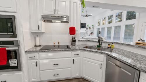 a white kitchen with white cabinets and a sink at Serene Escape by the Lake home in Montgomery