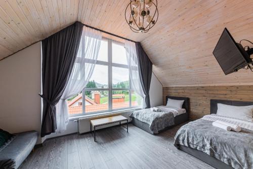 Un dormitorio con dos camas y una gran ventana. en Haya Villa, en Bukovel