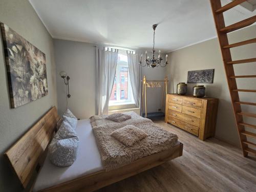 a bedroom with a bed and a dresser and a window at Palais Picard Westflügel in Thale