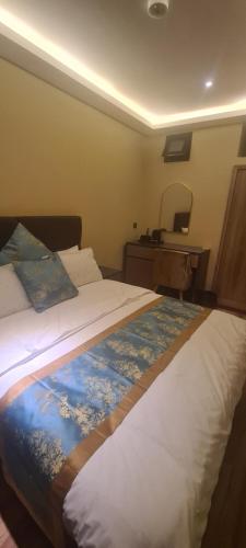 a bedroom with a bed with a dresser and a desk at Taj mahal residencial in Maputo