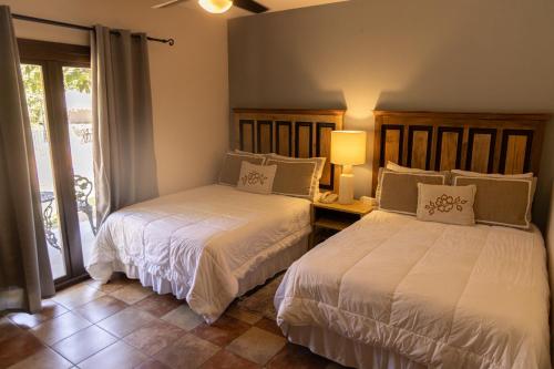 two beds in a room with a window at Hotel Cubitá Boutique Resort & Spa in Chitré