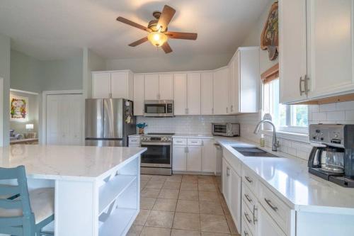 a kitchen with white cabinets and a ceiling fan at Kingfish Cove in Summerland Key