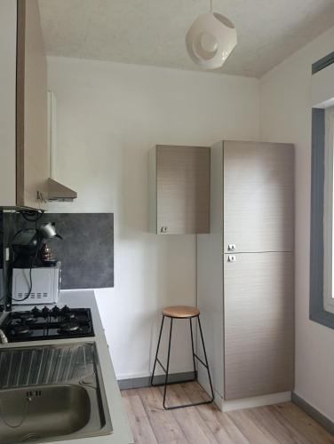 a kitchen with a stove and a sink and a stool at Appartement 2 hyper centre Lorient in Lorient