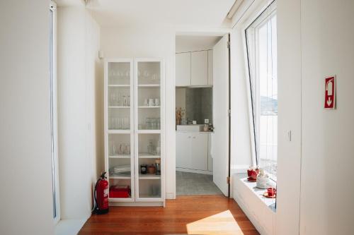 a kitchen with white cabinets and a large window at Sea & Rocks 15 - House in Lagoa