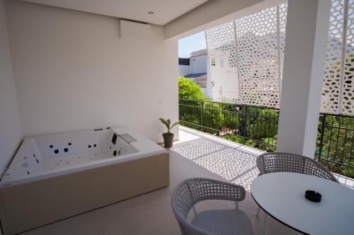 a bathroom with a tub and a table and chairs at B&B Le Muse in Mondello