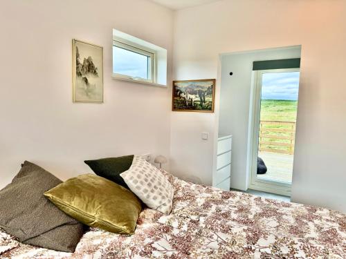 a bedroom with a bed with pillows and a window at Mossberg Luxury 3 bedroom Villa in Selfoss