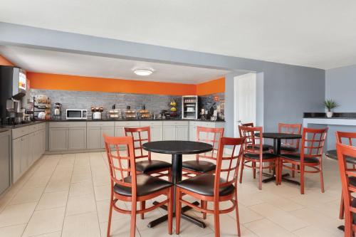 a dining room with two tables and chairs and a kitchen at Howard Johnson by Wyndham Harrisonburg in Harrisonburg