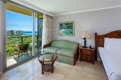 Un dormitorio con una cama, una silla y una ventana en Luana Waikiki Oceanview High Floor Condo 1210, en Honolulu
