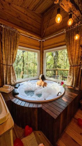 a child in a bath tub in a room with a window at Cabana hidromassagem Morada Alma Gêmea in Campo Alegre