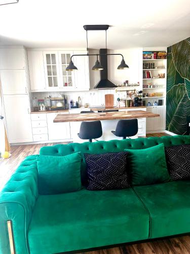 a green couch in a living room with a kitchen at Vila Vista Verde in Zaklopača