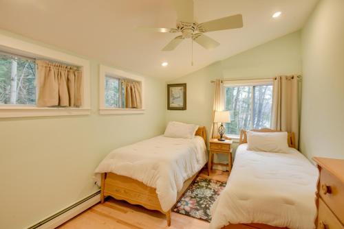 a bedroom with two beds and a ceiling fan at Falmouth Vacation Rental On Highland Lake! in Falmouth