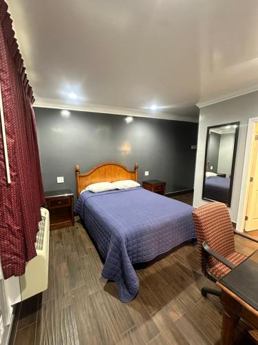 a bedroom with a bed and a table and a mirror at Travelers INN in West Sacramento