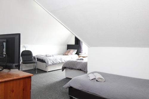 a bedroom with two beds and a tv in a room at Pebbles guest house in Southampton