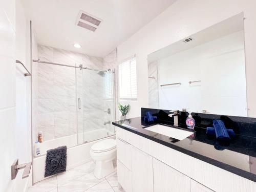 a white bathroom with a sink and a shower at Cozy 3 BR Townhouse with Balcony in Los Angeles