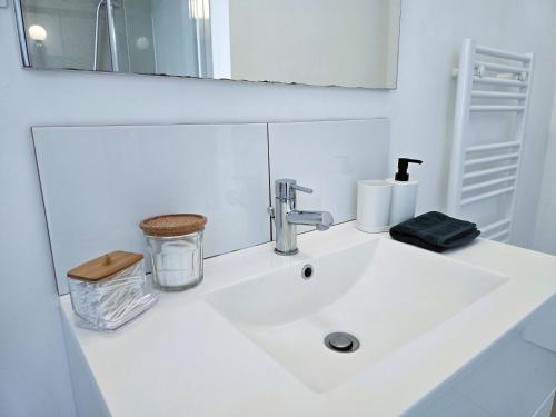 un lavabo de salle de bain blanc avec un robinet et un miroir dans l'établissement Le Cinq, à Metz