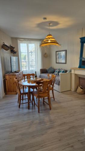 un salon avec une table, des chaises et un canapé dans l'établissement L'endroit idéal au croisic, au Croisic