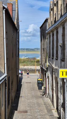 une femme marchant dans une rue entre deux bâtiments dans l'établissement L'endroit idéal au croisic, au Croisic