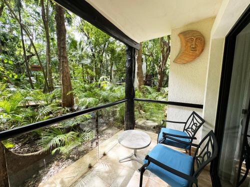 a screened in porch with two chairs and a table at The Reef Playacar Beach Resort & Spa-Optional All Inclusive in Playa del Carmen