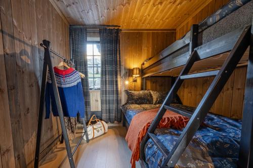 a bedroom with bunk beds in a wooden room at Storefjell Resort - Panorama apartments in Gol