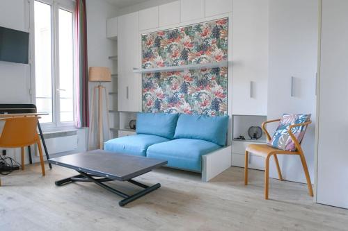 un salon avec un canapé bleu et une table dans l'établissement Shelter Oberkampf, à Paris
