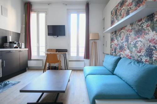 un salon avec un canapé bleu et une table dans l'établissement Shelter Oberkampf, à Paris