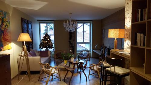 a living room with a christmas tree and a table and chairs at Aux Pierres Magiques in Saint-Laurent-de-Chamousset