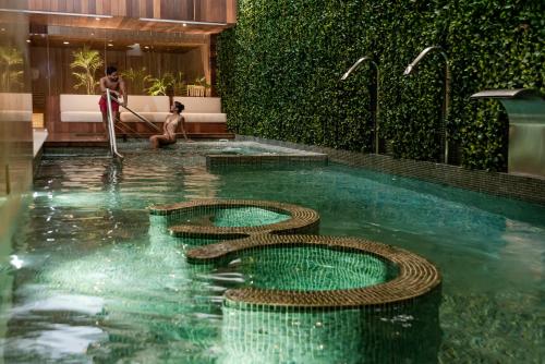 a pool with two snakes in the water at The Reef 28 Hotel & Spa - Luxury Adults Only - All Suites - With Optional All Inclusive in Playa del Carmen