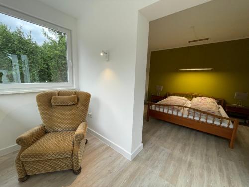 a bedroom with a bed and a chair and a window at geräumige Wohnung mit Terrasse in Halle Westfalen