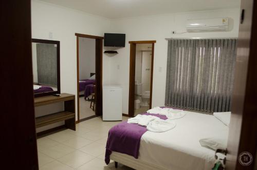 a hotel room with a bed and a television at Hotel São Paulo in Rio Grande