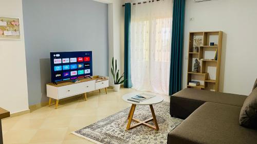 a living room with a couch and a tv at Divjaka Apartments 3 - City Center in Divjakë