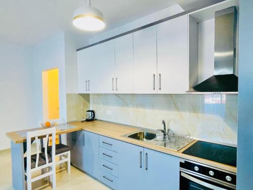 a kitchen with white cabinets and a sink at Divjaka Apartments 3 - City Center in Divjakë