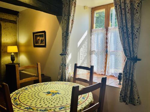 une salle à manger avec une table et une fenêtre dans l'établissement La Meltiere a Beautiful 2-Bed Cottage in Courcite, à Courcité