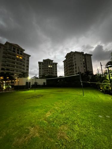 a field of grass with buildings in the background at Luxury Condo at Jaco Bay, Costa Rica's best beach in Jacó
